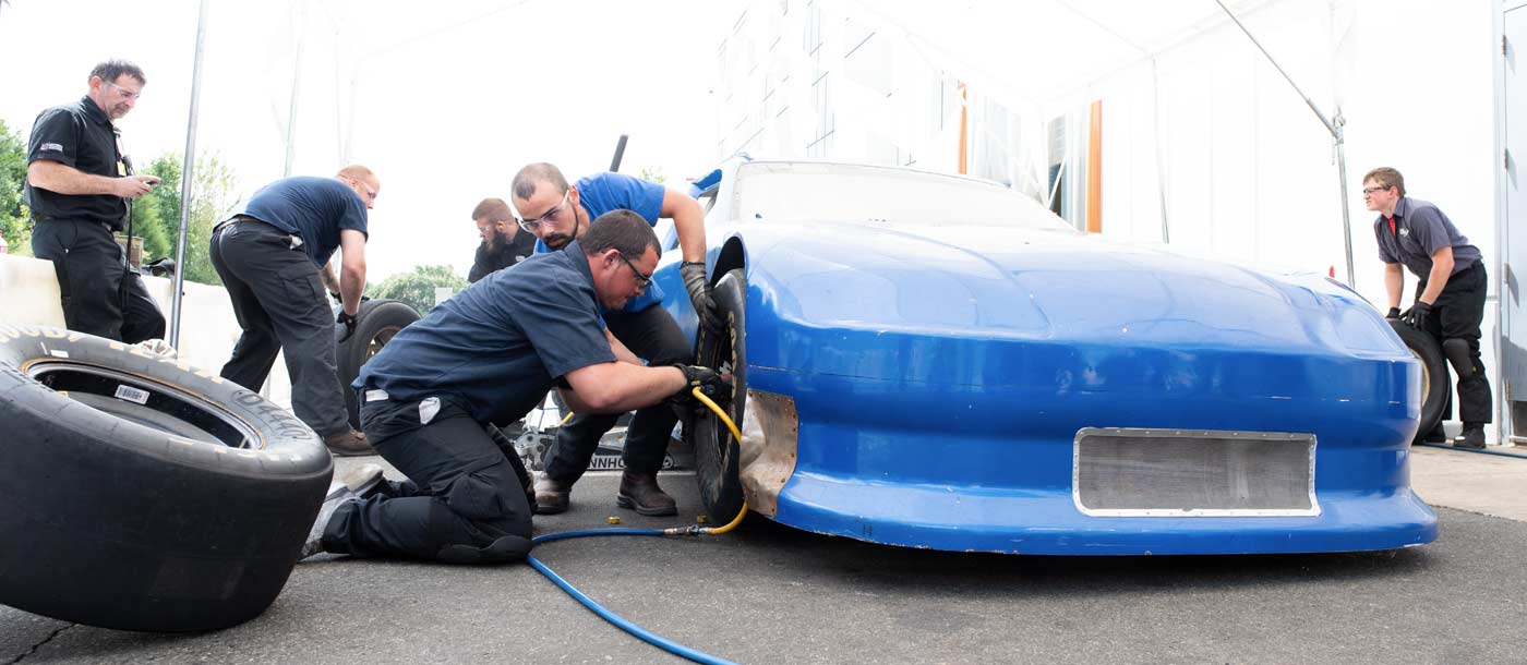 An image of students changing a tire at NASCAR Technical Institute in Mooresville, North Carolina